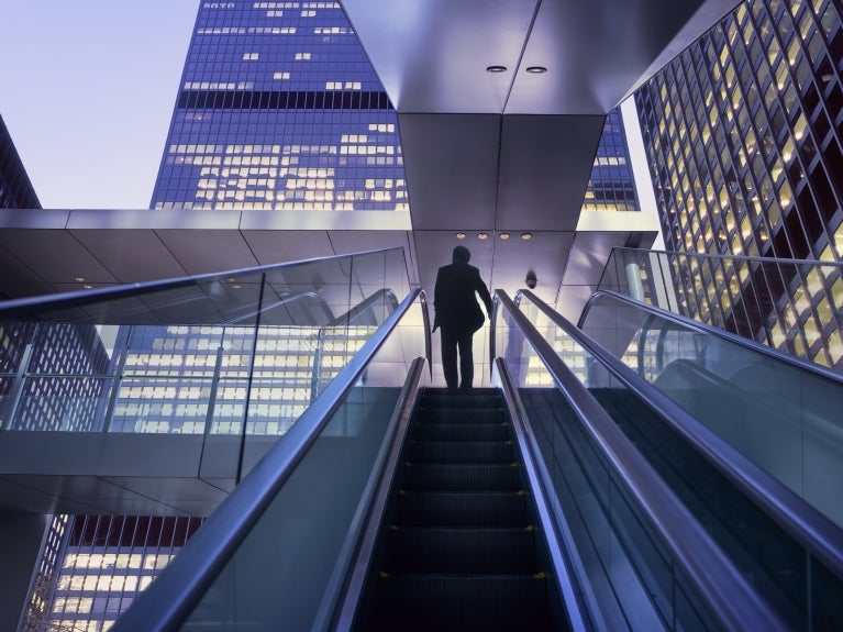 person going up escalator 