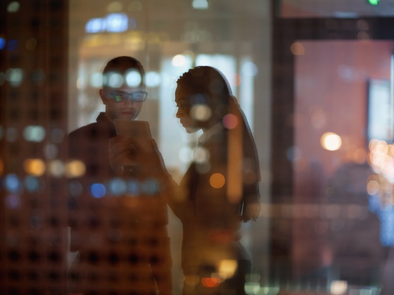 Employees on a tablet reflected in window