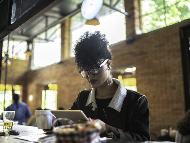 Businesswoman working inside a restaurant, using digital tablet