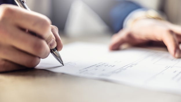 Person signing a paper