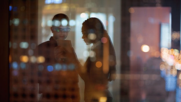 Employees on a tablet reflected in window